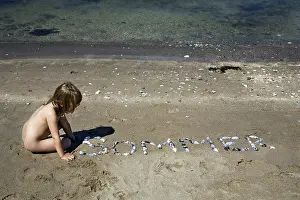 Child Playing with Shells Print on Beach