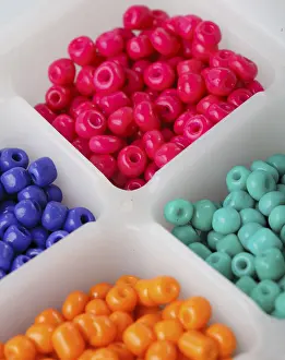 Prismatic Colors Prints: Close up multi colored beads heap in box