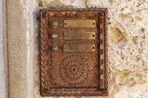 Traditional Building Design Prints: Close up of an old rusty intercom embedded in weathered stone wall