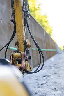 Black Forest Machinery Prints: Close-up of a construction machine with hoses on a construction wall