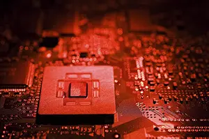 Computer Motherboard Prints: Close-up of red lighted microchip on electronic computer circuit board