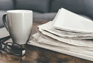 Cozy Living Room Scene Prints: close-up shot of stack of newspapers
