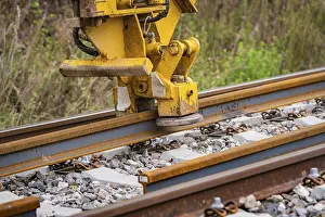 Yellow Construction Machine Prints: Close-up of a yellow construction machine working on a rail