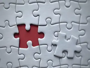 Red Background Image Prints: Closeup of a puzzle with a missing piece against a red background