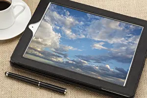 Cloud Computing Concept Prints: Cloud computing concept - a stormy cloudscape on digital tablet computer together with a cup of coffee and stylus pen