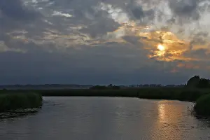 Nature Park Peenetal Prints: Cloudy sky at sunset over a river with slight reflection