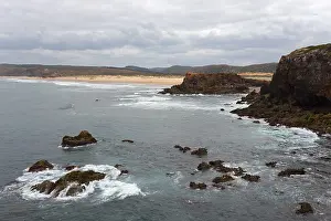 Rocky Coastal Area Prints: Coast with rocks and waves under a cloudy sky