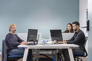 Office Collaboration Prints: Colleagues in a co-working office working while using computers