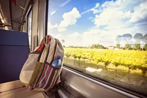 Deserted Train Station Scene Prints: Colorful backpack on the train near the window
