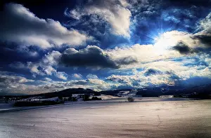 Southern Germany Tourist Attractions Prints: Colourful winter landscape with dramatic clouds and sun rays over snow-covered fields