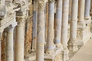 Prints of Columns on the stage of the amphitheater. Ancient antique amphitheater in the city of Hierapolis in Turkey. Steps and antique statues with columns in the amphitheater Turkey Heritage Site Prints: Columns on the Stage of an Ancient Amphitheater Print