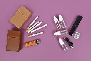 Transporting Goods By Sea Prints: Comparison between electronic and real cigarette with tools on violet background