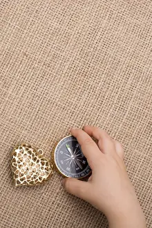 Heart Symbol Prints: Compass, key and a heart shaped object beside a hand