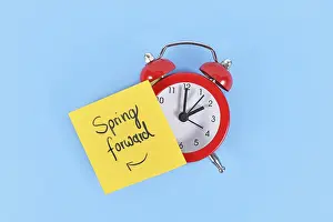 Daylight Saving Time Concept Prints: Concept for summer daylight saving time with clock and note saying Spring forward