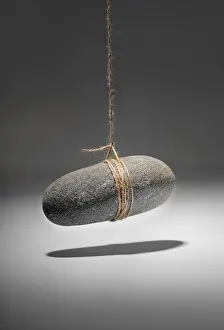 Studio Still Lifes Prints: Conceptual image of a small rock hanging on a string