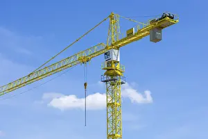 Construction Crane Prints: Construction crane in front of a blue sky, clouds