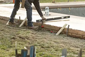 Building Inspection Prints: Construction worker checking level on wet deck cement