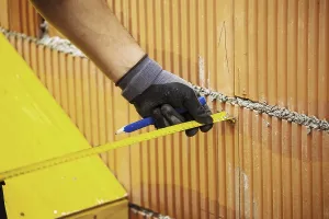 Residential Building Prints: Construction worker erecting a brick wall in a building shell