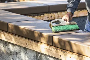 Real Estate Property Development Prints: Construction worker using brush on wet cement forming coping around new pool