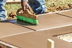 Cement Finishing Techniques Prints: Construction Worker Using Brush On Wet Cement Forming Coping Around New Pool