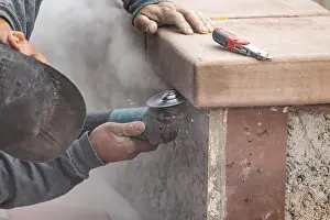 Male Construction Worker Prints: Construction worker using grinder at construction site