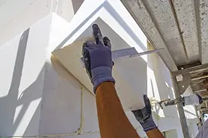 Energy Efficient Building Prints: Construction workers insulate a house facade