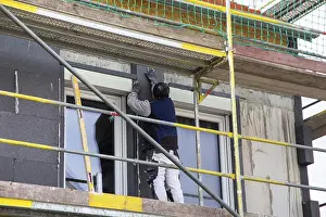 Residential Building Insulation Prints: Construction workers insulate a house facade