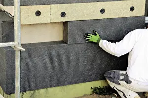 Exterior Wall Insulation Prints: Construction workers insulate a house facade