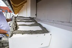 Residential Building Insulation Prints: Construction workers insulate a house facade