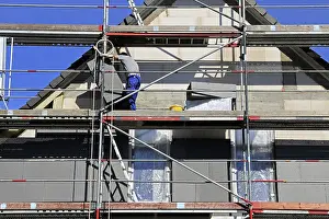 House Facade Insulation Prints: Construction workers insulate a house facade