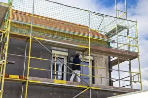 House Facade Insulation Prints: Construction workers insulate a house facade