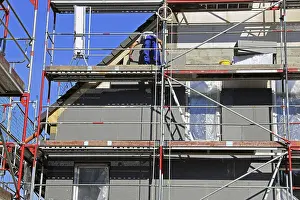House Facade Insulation Prints: Construction workers insulate a house facade