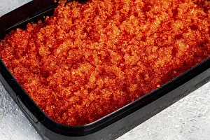 Prints of Container with orange caviar, flying fish, Tobiko, on the table, caviar for rolls and sushi, close-up Flying Fish Prints: Container with Orange Caviar Print