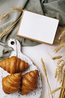 White Background Still Life Prints: Croissants beside their packaging
