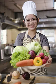 Nutrition And Meal Planning Prints: A culinary student stands in a professional training kitchen