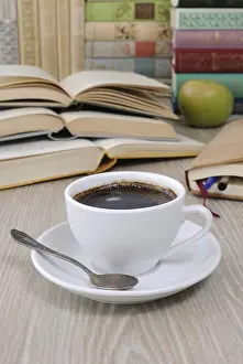 Empty Table Setting Ideas Prints: A cup of coffee on the table against the background of an open book with a notebook and a stack of books