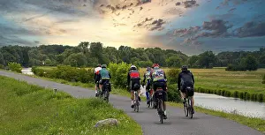 Lower Oder Valley National Park Prints: Cyclist on a cycle path by the river