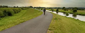 Cyclist On Cycle Path Prints: Cyclist on a cycle path by the river