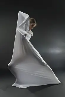 Dark Background Dance Prints: A dancer gracefully interacts with white fabric