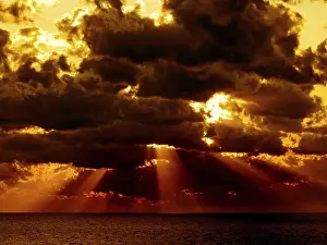 Severe Weather Conditions Prints: Dark clouds with sun rays over sea