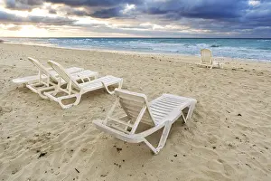 Uninhabited Coast Prints: Deckchairs on a beach on a background of ocean