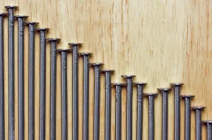Construction Industry Supplies Prints: Declining Graph of Nails on a Wood Background