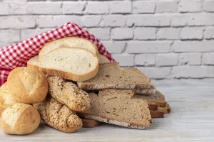 Country Style Kitchen Utensils Prints: Different types of bread rusticly draped on a wooden table