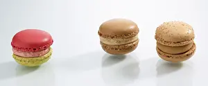 French Dessert Prints: Three differently coloured macarons in front of a white background