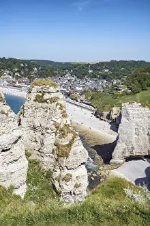 Prints of Distinctive rock formation and landmark Chambre des Demoiselles on the chalk cliffs of Falaise d'Aval near Etretat, behind it the pebble beach with the seaside resort of Etretat, English Channel Demoiselle Prints: Chambre des Demoiselles Print - Falaise d'Aval, Étretat, France