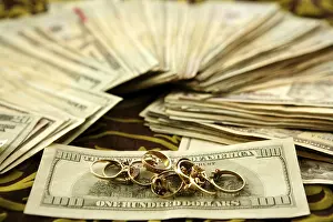 Payment Transaction Prints: Dollar notes and gold rings over tablecloth