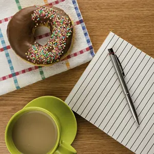 Breakfast Table Setup Prints: Doughnut coffee and notepad with pen on a table