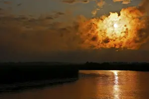 Atmospheric Evening Light Sky Prints: Dramatic cloud formation at sunset reflected in a calm river
