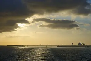 Evening Light In France Prints: Dramatic clouds and setting sun reflect in calm sea