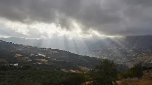 Cloudy Sky Landscapes Prints: Dramatic landscape with sun rays breaking through a cloud cover